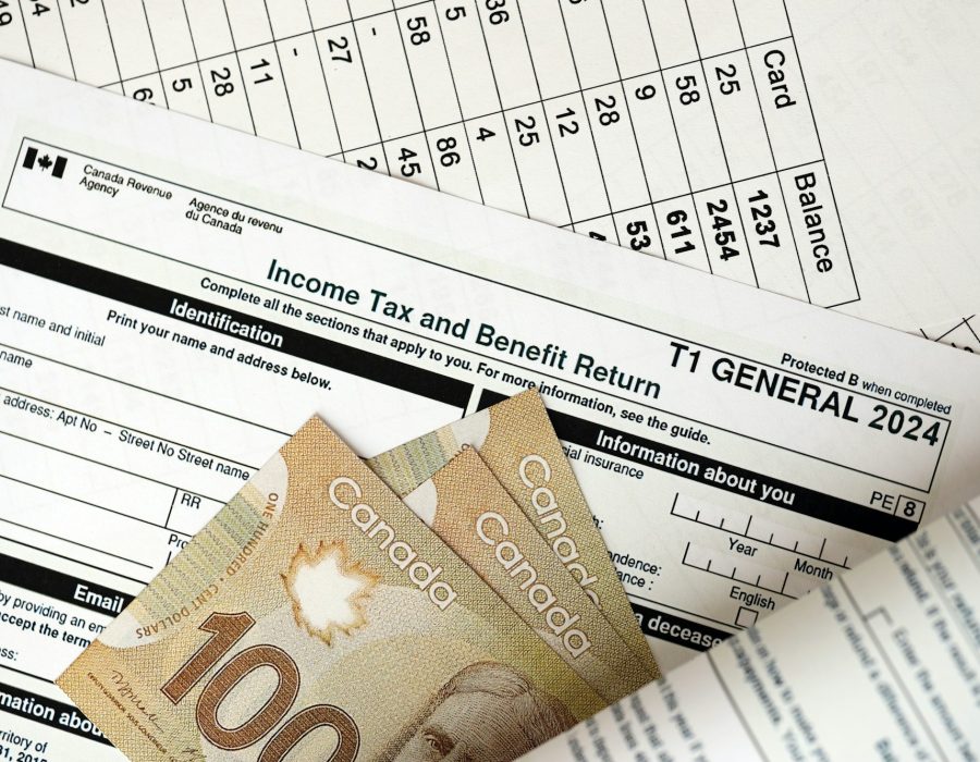 Canadian T1 General tax form Income tax and benefit return lies on table with canadian money bills